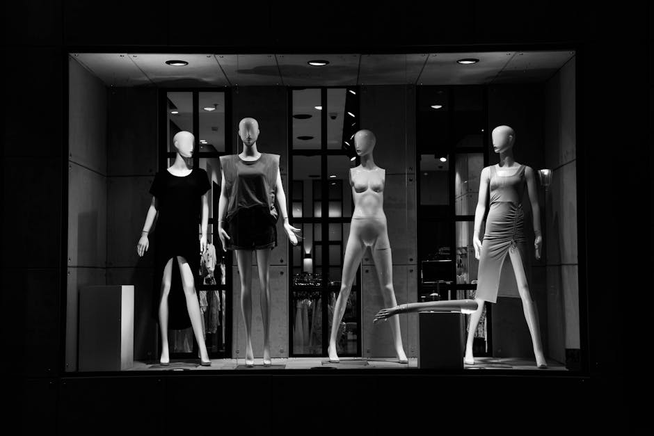 Elegant fashion mannequins showcased in a monochrome boutique window display.